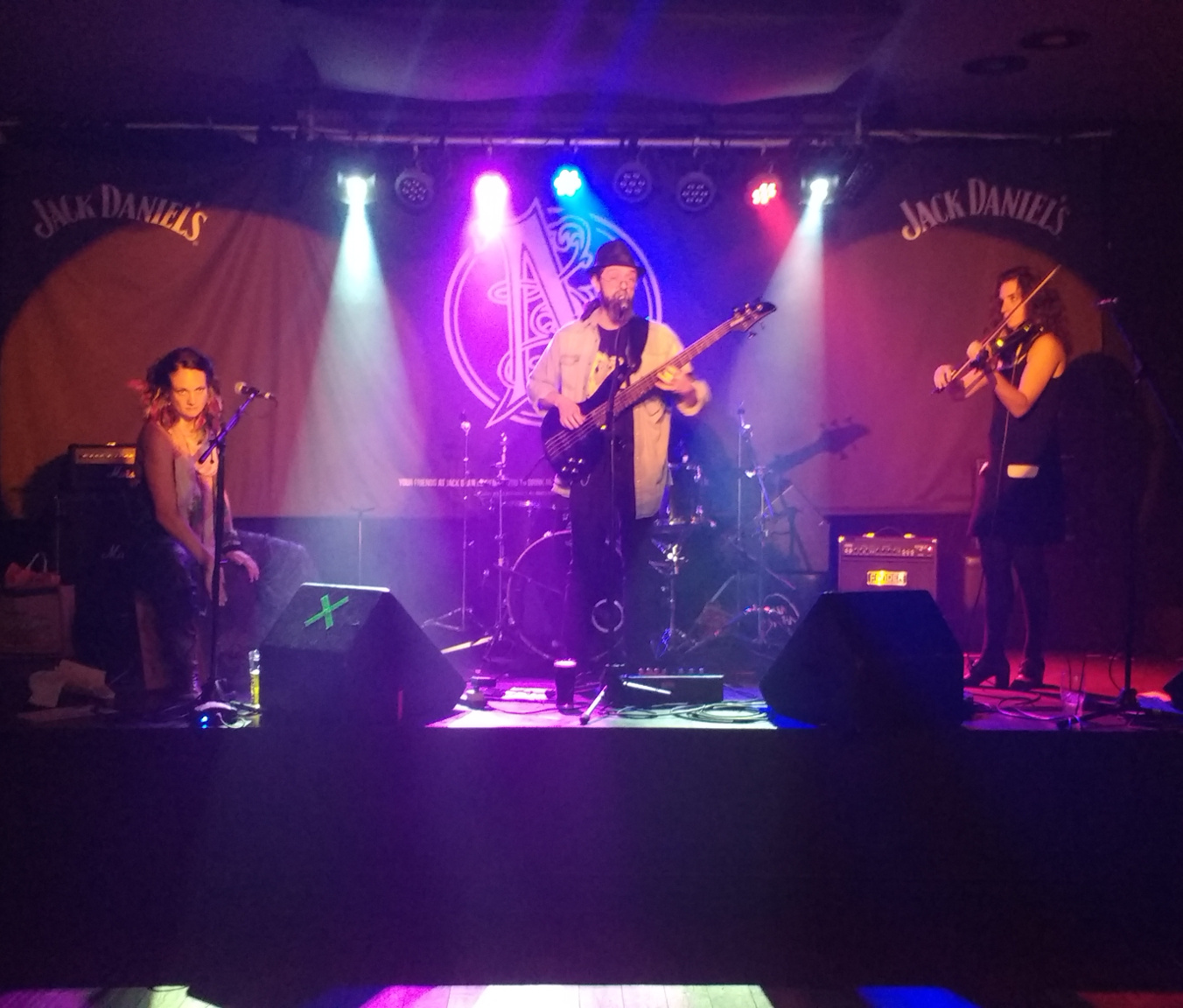 Fit and the Conniptions on the raised and artfully lit stage at Nambucca. Left to right: H on cahon, Wayne on bass and vocals, Hana Piranha on violin.